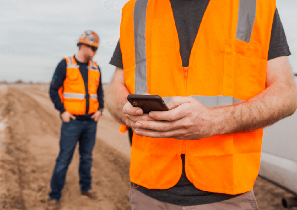 construction worker accessing construction document management system in field via mobile app.